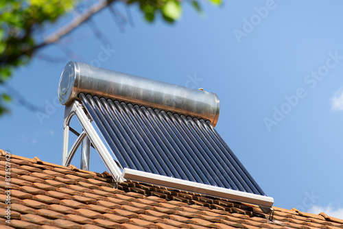 solar water heater on a roof top, solar water heating panel, blue sky in the background