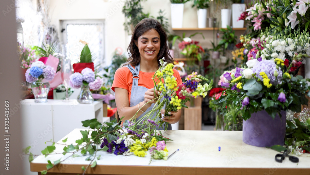 Young florist working at the flower shop and making a beautiful arrangement Young florist working at the flower shop and making a beautiful arrangement