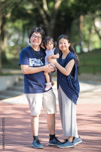 A Chinese Malaysian family - parents in their 30s and their 1-year-old daughter - playing in KLCC Park at Kuala Lumpur City Centre クアラルンプール・シティ・センターにあるKLCC公園で30代の中国系マレーシア人の両親と1歳の娘が遊んでいる