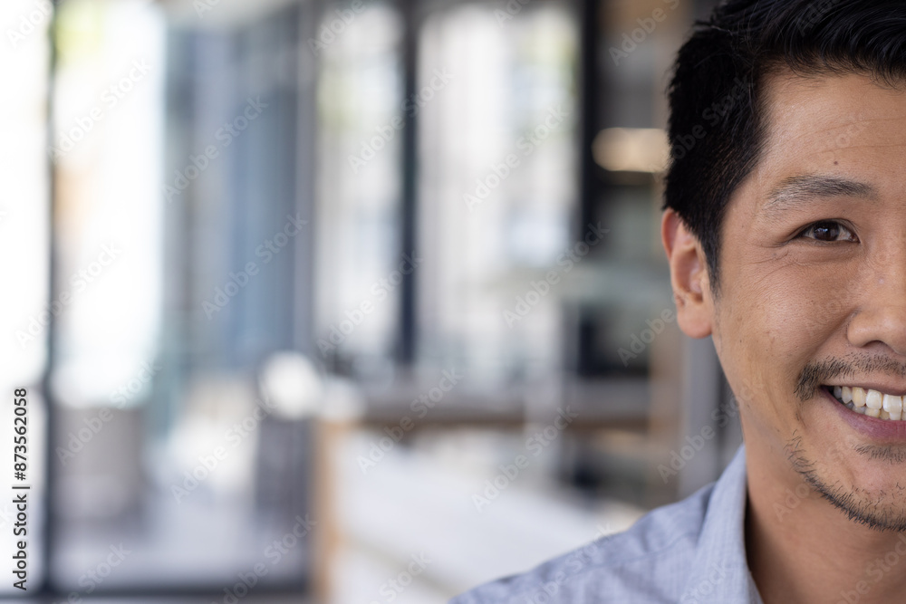 Smiling man in office, focusing on work and looking at camera, copy space Smiling man in office, focusing on work and looking at camera, copy space