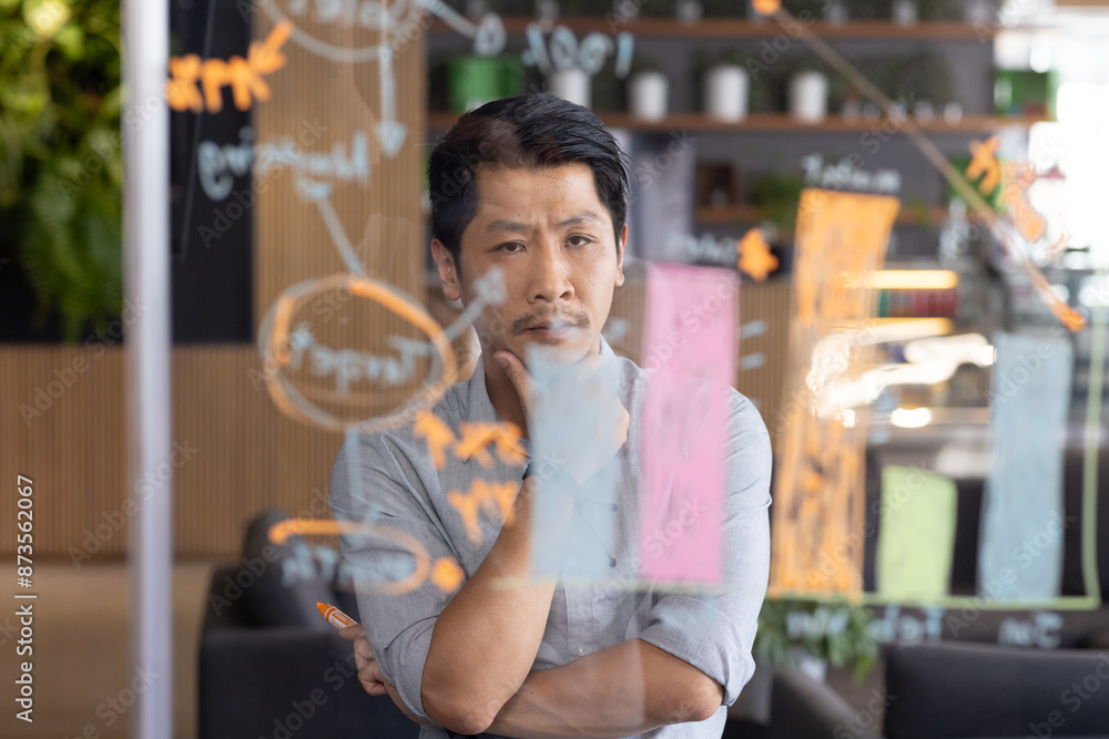 © Wavebreak Media - Thinking deeply, man analyzing project plan on transparent board in office