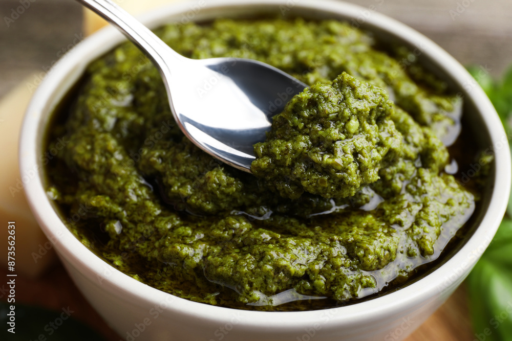 Taking tasty pesto sauce at table, closeup Taking tasty pesto sauce at table, closeup