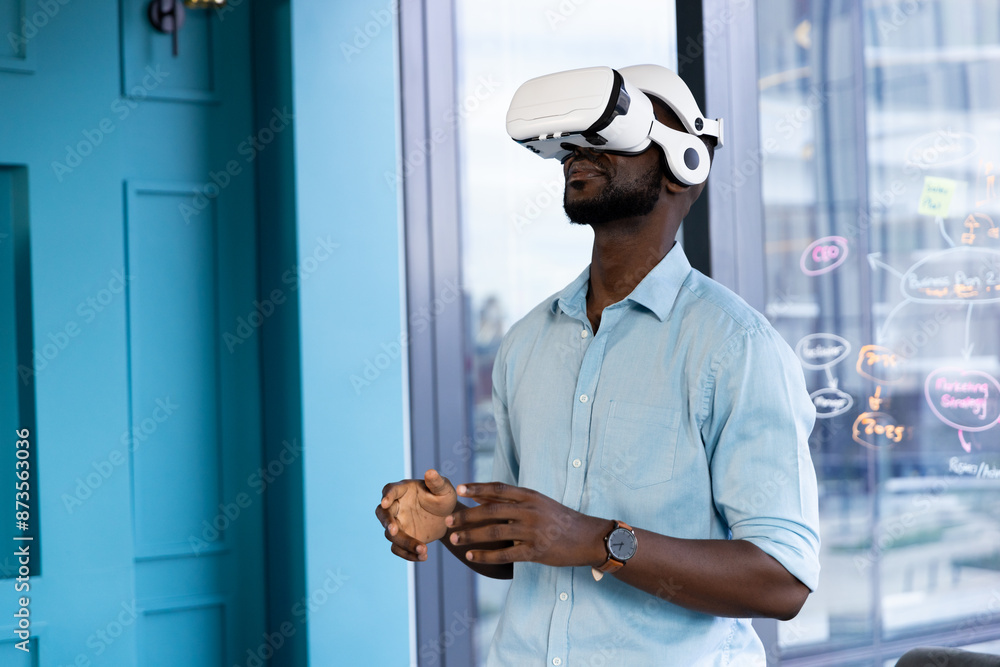 Using VR headset, man exploring virtual reality experience in modern office Using VR headset, man exploring virtual reality experience in modern office