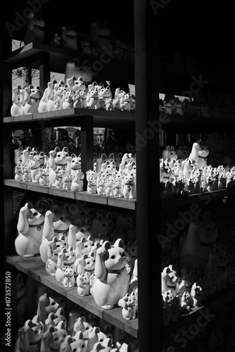 Canvas Print A black and white photo of shelves overflowing with Maneki-neko cat figurines of