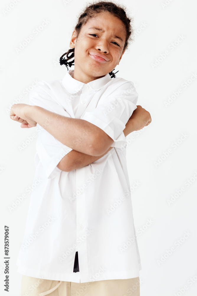 Confident young boy in stylish outfit standing with arms crossed in a trendy pose Confident young boy in stylish outfit standing with arms crossed in a trendy pose