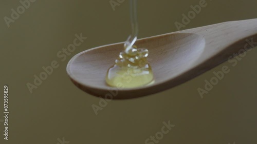 Honey dripping onto a wooden spoon