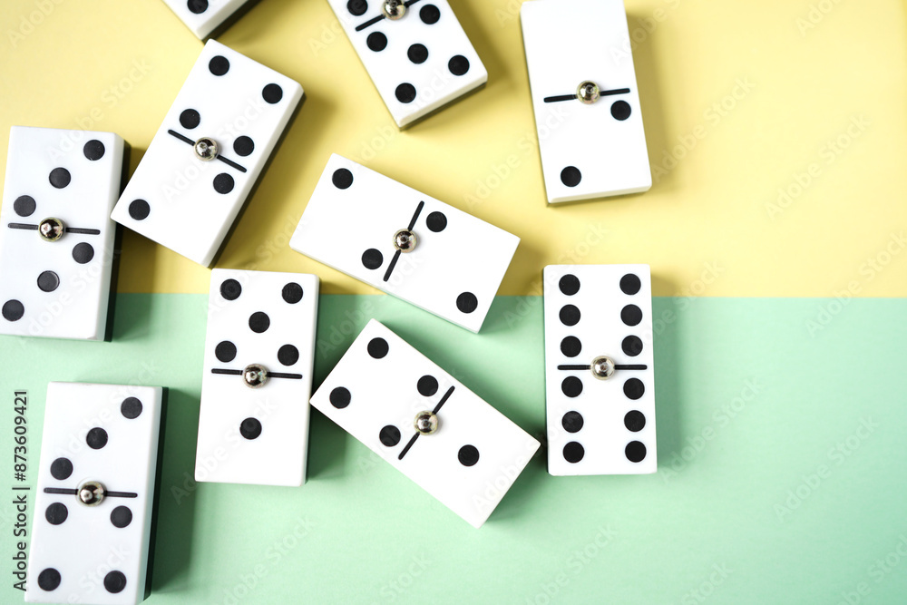 White domino blocks on yellow and green background. There are some benefits of playing domingo; helps to develop critical thinking skills, bond with families and social groups. White domino blocks on yellow and green background. There are some benefits of playing domingo; helps to develop critical thinking skills, bond with families and social groups.