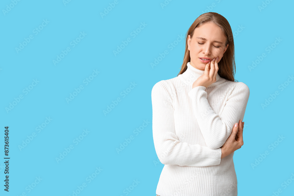 Beautiful young woman suffering from toothache on blue background Beautiful young woman suffering from toothache on blue background