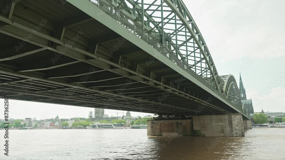 View of cologne cathedral and Hohenzollern Bridge from right side and ships on Rhine river slow motion. Famous Cologne Bridge and moving clouds in the sky View of cologne cathedral and Hohenzollern Bridge from right side and ships on Rhine river slow motion. Famous Cologne Bridge and moving clouds in the sky