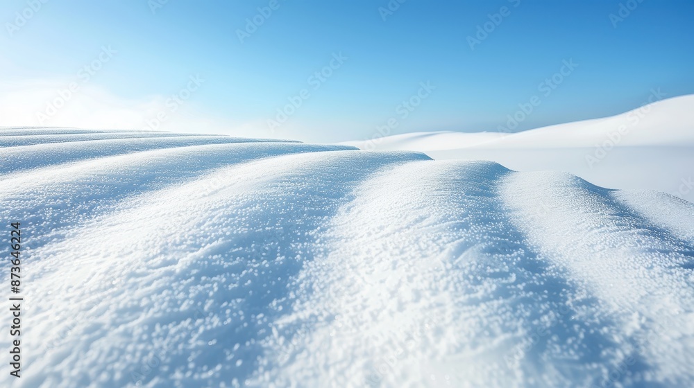 A snowy field with a blue sky in the background A snowy field with a blue sky in the background