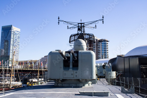 An exquisite image showcasing the elegance and power of an Australian naval warship, featuring a striking white cannon with two imposing black barrels.
