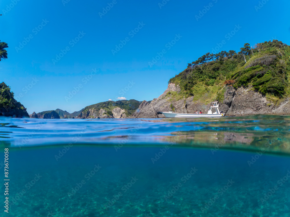 Fototapeta premium ヒリゾ浜渡船の漁船の美しい半水面撮影。日本国静岡県伊豆半島賀茂郡南伊豆町中木から渡し船で渡るヒリゾ浜にて。 2022年10月撮影。 