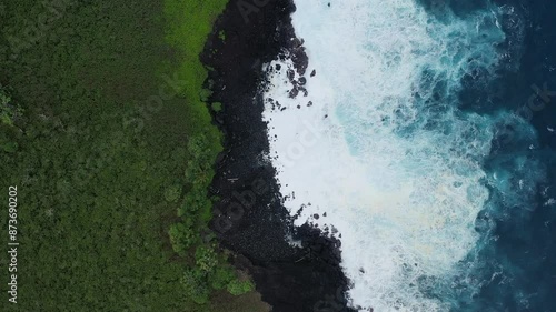 Wallpaper Mural Aerial view of waves crashing onto a rocky Hawaiian shoreline with lush green vegetation, captured in dramatic slow motion.
 Torontodigital.ca