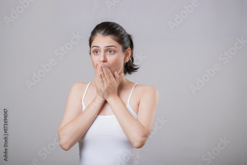 Attractive Girl With Both Hands Covering Her Mouth And Her Wide Eyes Giving A Shocked Expression