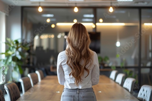 Confident businesswoman CEO stands firmly in a conference room.