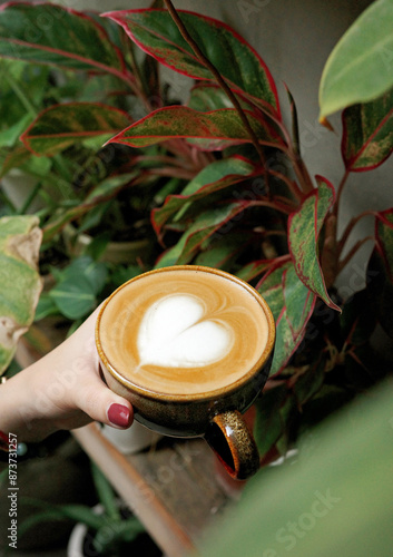 Relaxing coffee break at a home office with a monstera plant. Perfect for work-from-home, freelancer, and cozy vibes keywords.