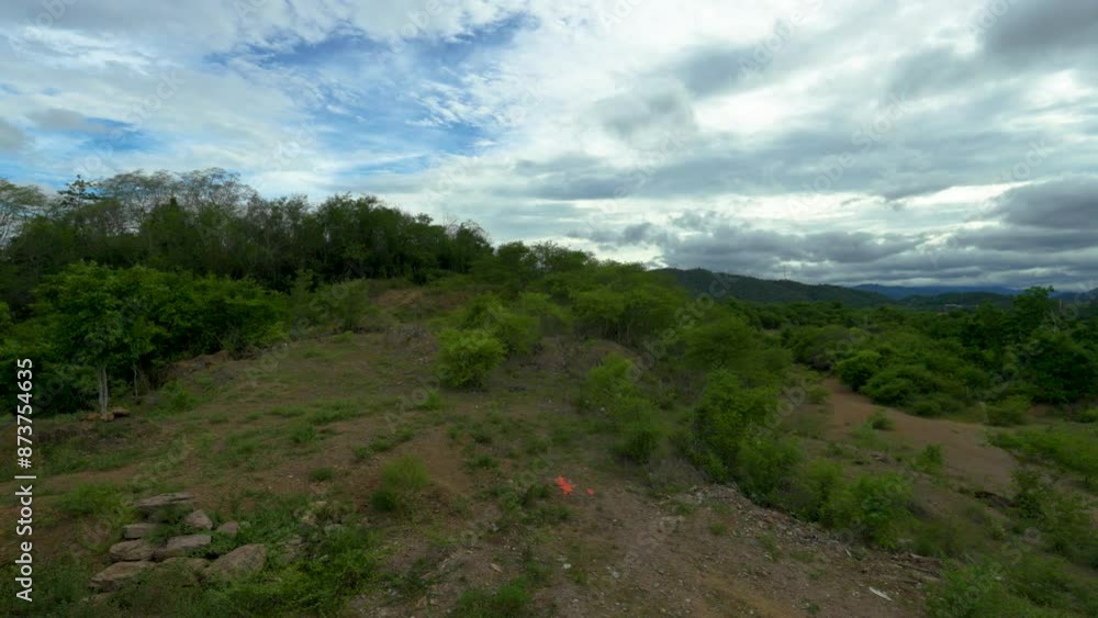 Panning sideward moveing view of mountainous landscape with cloudy sky in the background. Panning sideward moveing view of mountainous landscape with cloudy sky in the background.