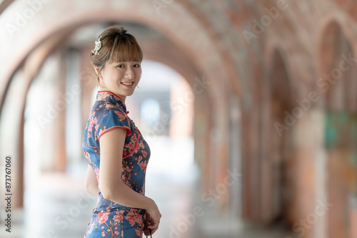 Young Taiwanese woman in her 20s wearing a blue cheongsam, strolling through a cultural district in Wanhua, Taipei, Taiwan photo