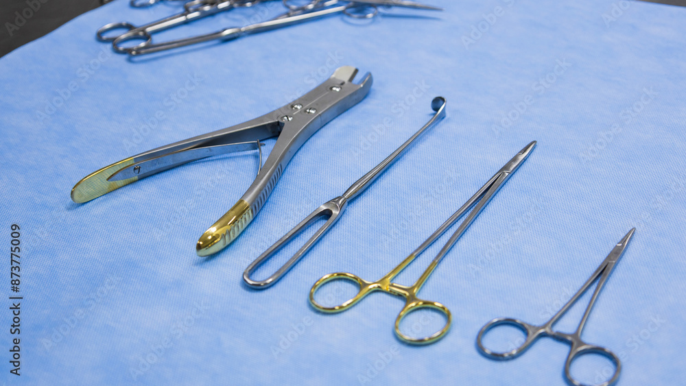 Fototapeta premium Stainless forceps medical scissors placed on a blue background. Medical instruments . Medical Surgical Instrument. Equipment used in surgery.