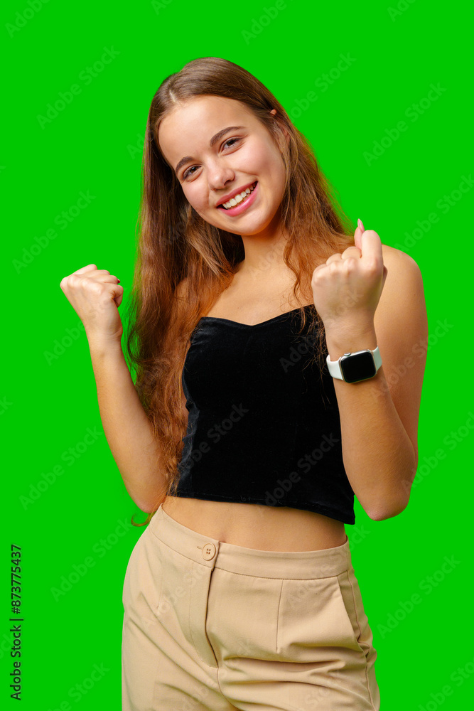 Young Woman Celebrating Success With Raised Fists Against Green Screen Background Young Woman Celebrating Success With Raised Fists Against Green Screen Background