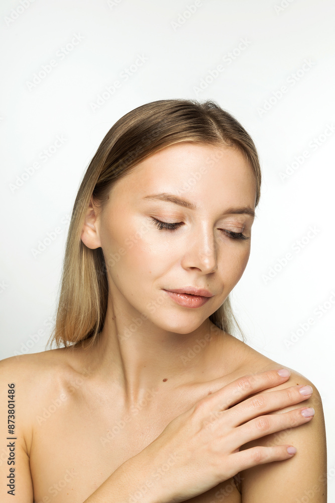 Woman with Smooth Skin and Bare Shoulders. Young Caucasian woman with flawless skin, bare shoulders, looking down and touching her shoulder. Woman with Smooth Skin and Bare Shoulders. Young Caucasian woman with flawless skin, bare shoulders, looking down and touching her shoulder.