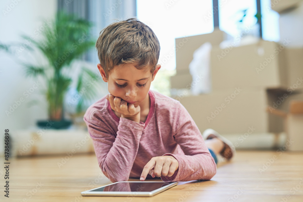 Kid, tablet and new home for relaxing browsing, elearning and educational games or boy in living room. Tech, video app and streaming cartoon or child development, lounge floor and online apartment Kid, tablet and new home for relaxing browsing, elearning and educational games or boy in living room. Tech, video app and streaming cartoon or child development, lounge floor and online apartment