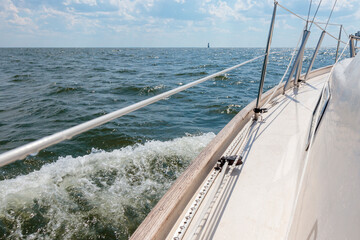 Tableau sur toile  Banner with sailing in an open sea with waves. View to the side deck. Classic sailboat. Summer adventure, recreation, cruise, vacations, regatta, sport in Finland, Gulf of Finland  © gudzar