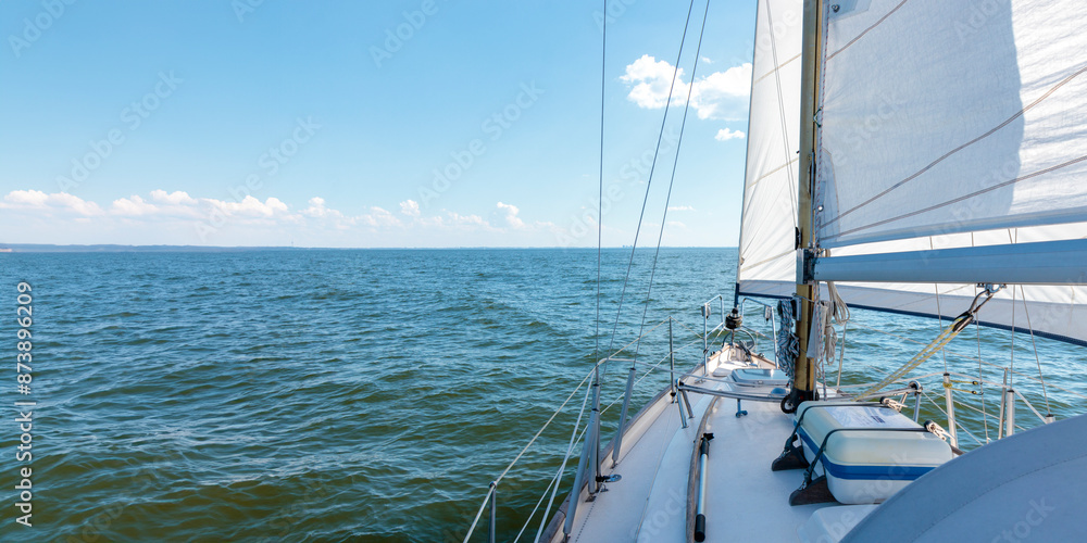 Luxury cruise on a sailing rigged yacht under a genoa and mainsail sailing in a light wind during the regatta. Yachting, sport, vacation. View from the deck to the bow, mast, sails. Banner Luxury cruise on a sailing rigged yacht under a genoa and mainsail sailing in a light wind during the regatta. Yachting, sport, vacation. View from the deck to the bow, mast, sails. Banner