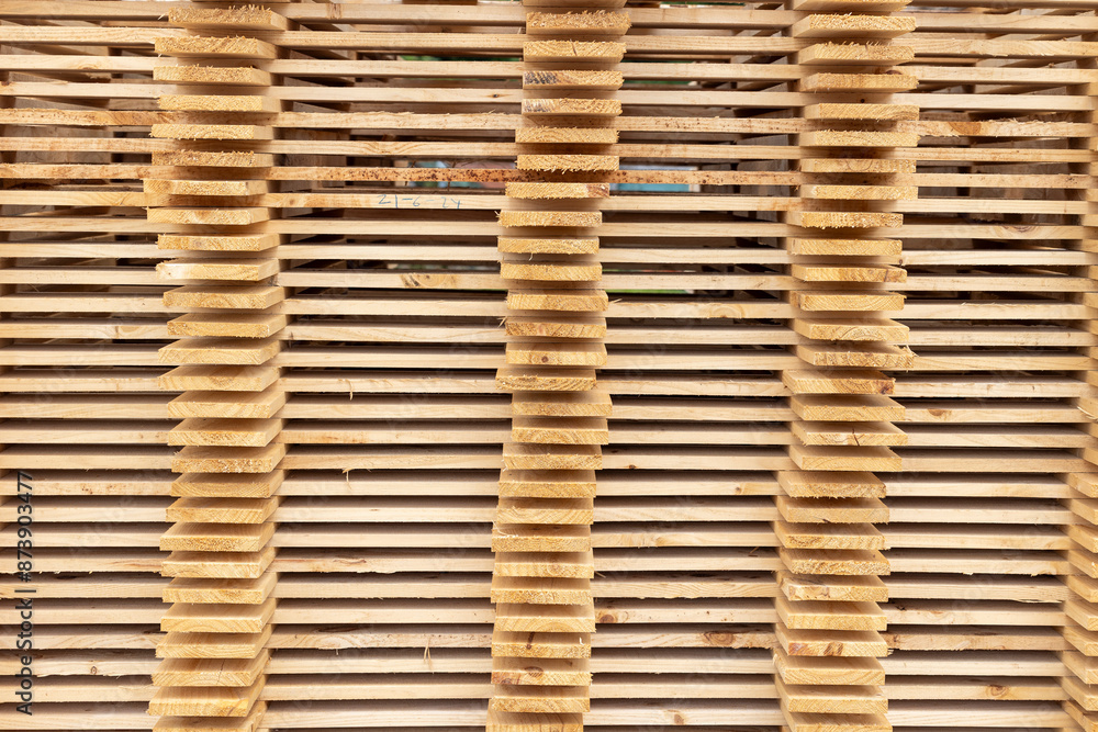 This image showcases a pile of neatly stacked wooden planks, varying in shades and textures, creating a rustic and organized appearance perfect for construction or carpentry themes. This image showcases a pile of neatly stacked wooden planks, varying in shades and textures, creating a rustic and organized appearance perfect for construction or carpentry themes.