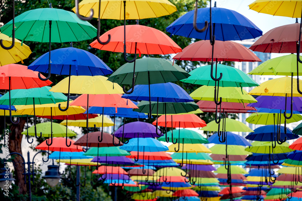 many colorful umbrellas fly and hover on the city street many colorful umbrellas fly and hover on the city street