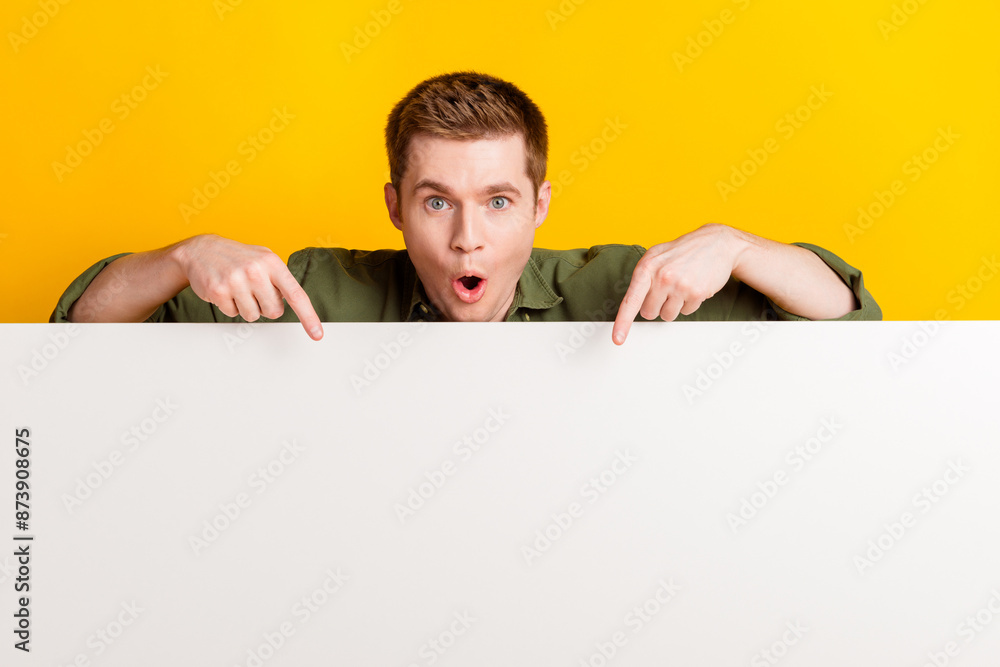 Photo of nice cheerful man wear stylish khaki clothes wow news empty space isolated on vivid yellow color background Photo of nice cheerful man wear stylish khaki clothes wow news empty space isolated on vivid yellow color background