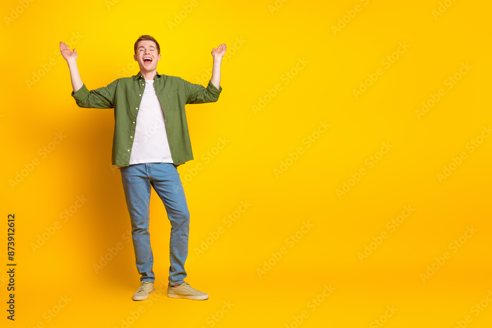 Photo of nice cheerful man wear stylish khaki outfit empty space poster isolated on vivid yellow color background Photo of nice cheerful man wear stylish khaki outfit empty space poster isolated on vivid yellow color background