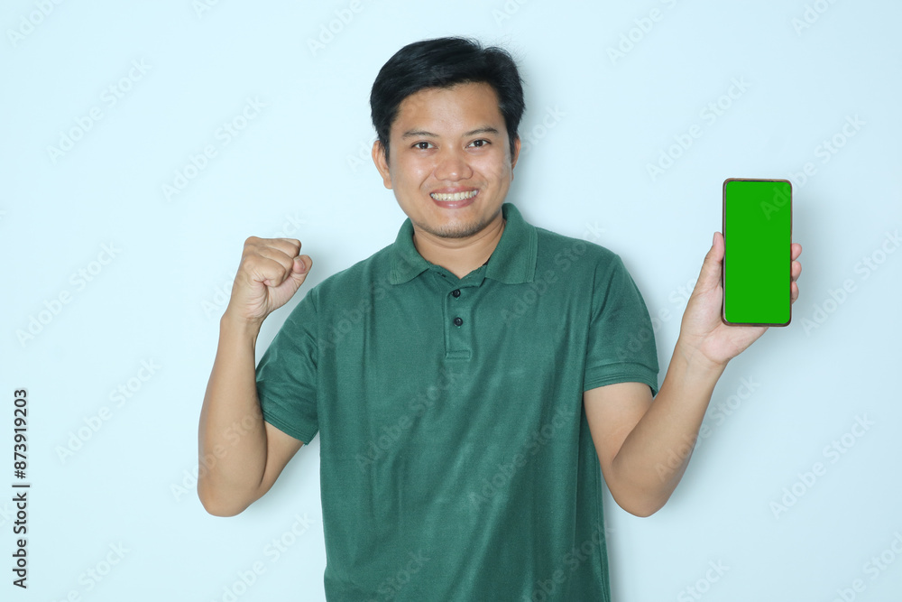 Young Asian man happy expression when showing green phone screen.Wearing a green t-shirt Young Asian man happy expression when showing green phone screen.Wearing a green t-shirt