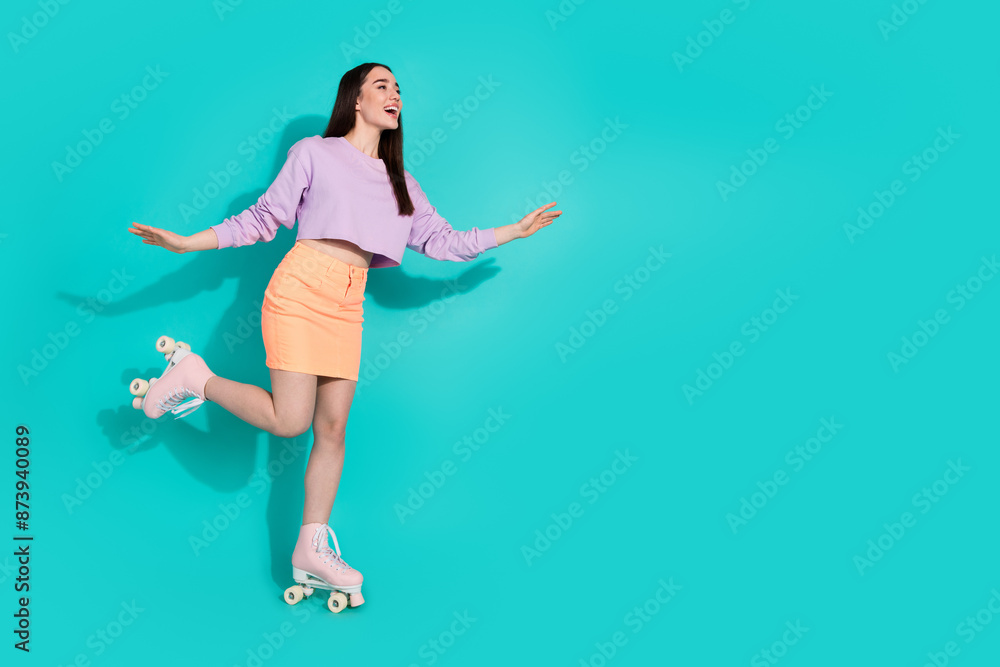 Full length photo of shiny carefree lady dressed mini skirt enjoying rollers empty space isolated blue color background Full length photo of shiny carefree lady dressed mini skirt enjoying rollers empty space isolated blue color background