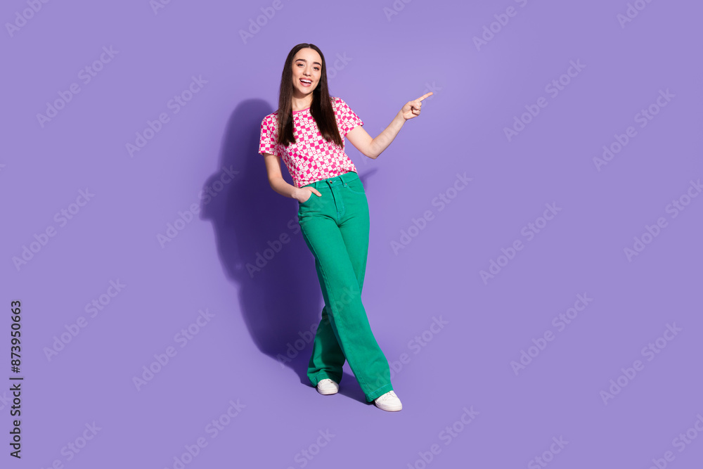 Full size photo of pretty young woman indicate finger empty space wear checkered t-shirt isolated on purple color background Full size photo of pretty young woman indicate finger empty space wear checkered t-shirt isolated on purple color background