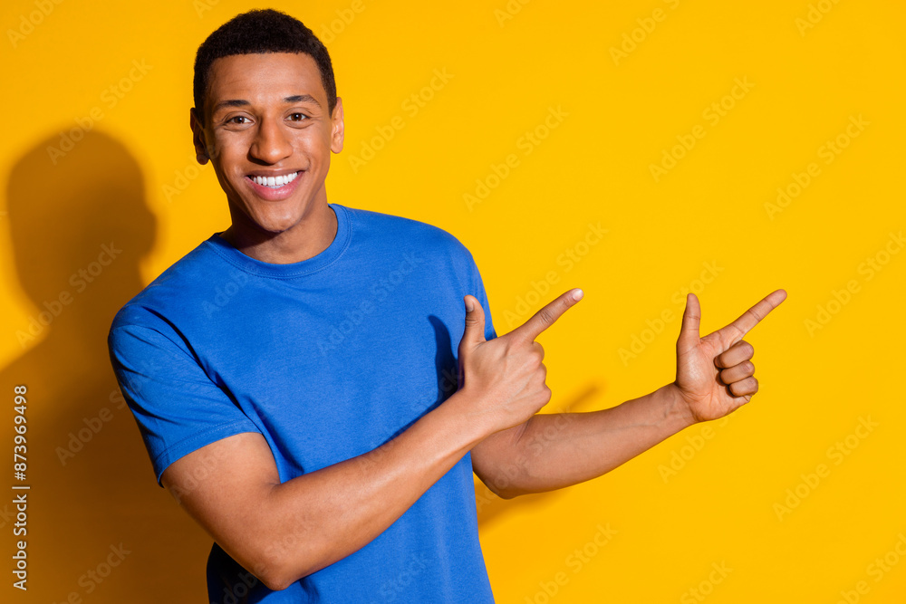 Photo portrait of attractive young man point empty space dressed stylish blue clothes isolated on yellow color background Photo portrait of attractive young man point empty space dressed stylish blue clothes isolated on yellow color background