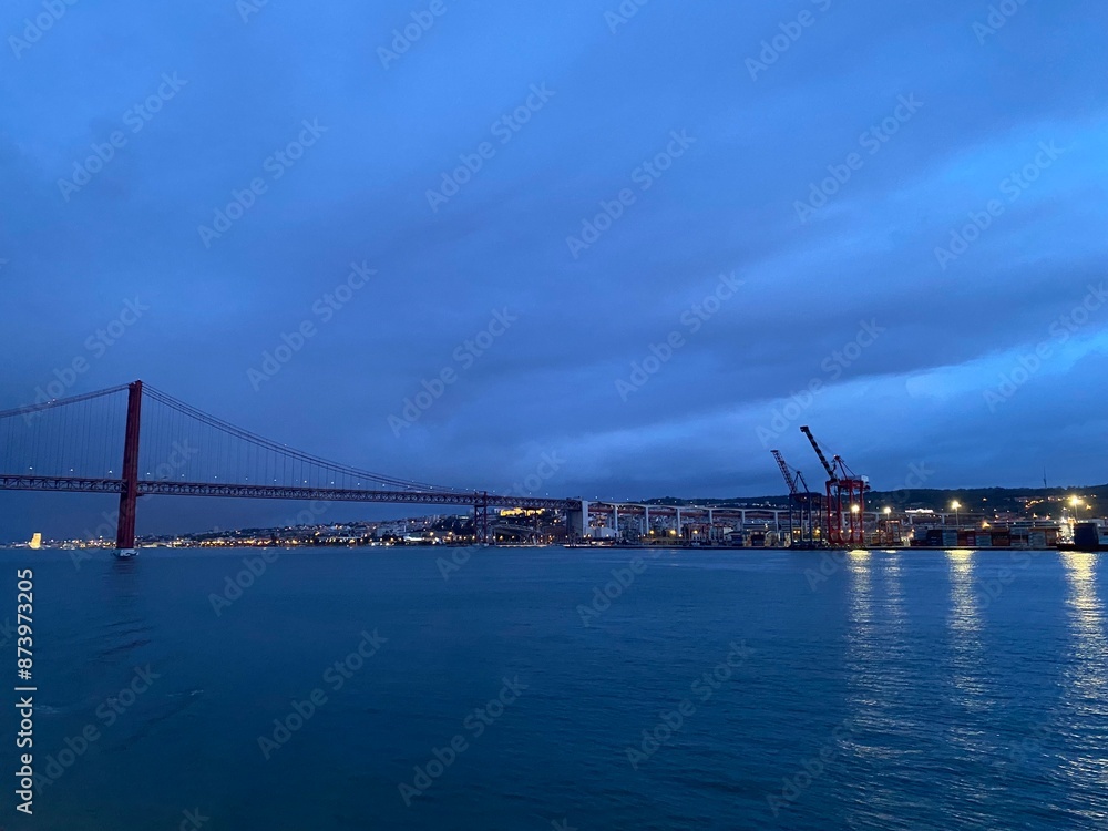 Fototapeta premium Panoramic view over the Ponte 25 de Abril and cranes in Lisbon harbour