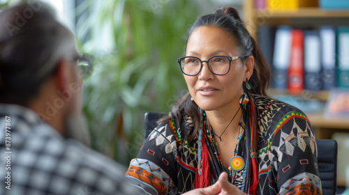 Aboriginal woman engaged in conversation with a man in an office setting