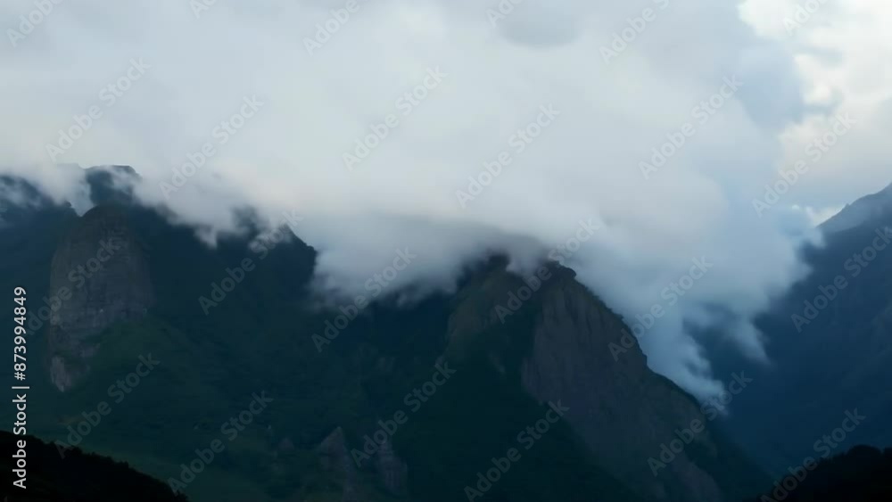 Misty mountain peaks shrouded in evening clouds Misty mountain peaks shrouded in evening clouds
