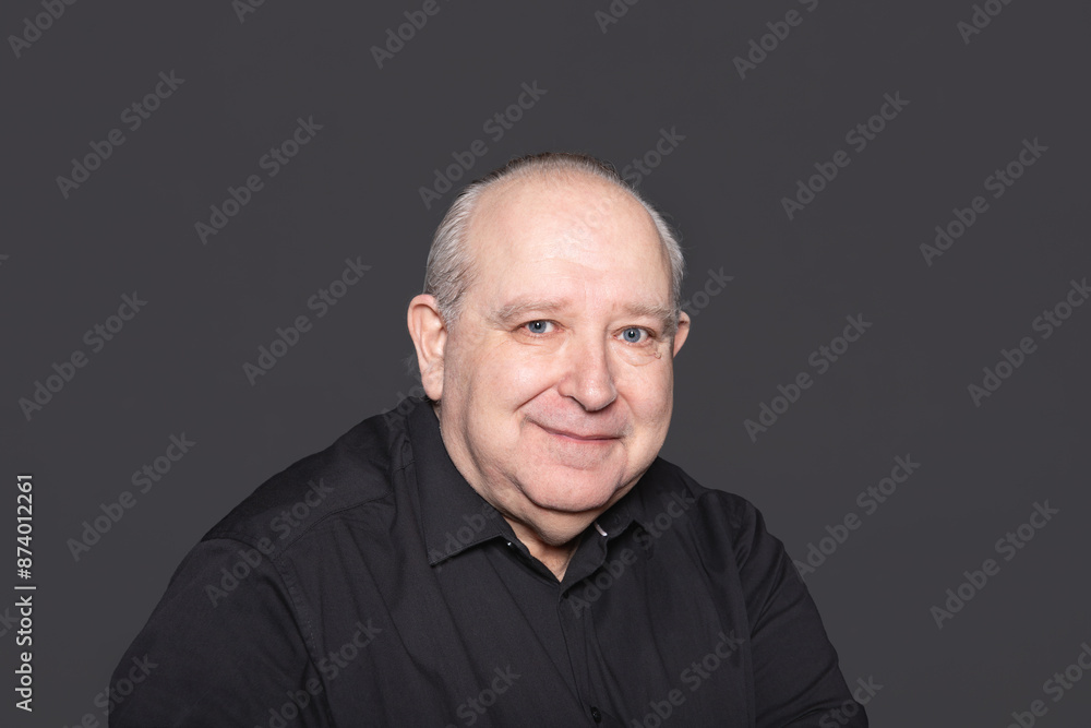 Obraz premium Portrait of a sexagenarian man with white hair and blue eyes, smiling and looking at the camera. Copy Space. Concept of aging
