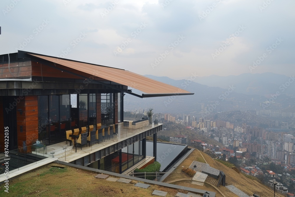 Modern hilltop house with large glass windows and a panoramic city view, creating a luxurious and serene atmosphere. Modern hilltop house with large glass windows and a panoramic city view, creating a luxurious and serene atmosphere.