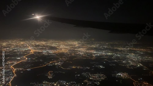 Glowing city at night. View from an airplane window.
