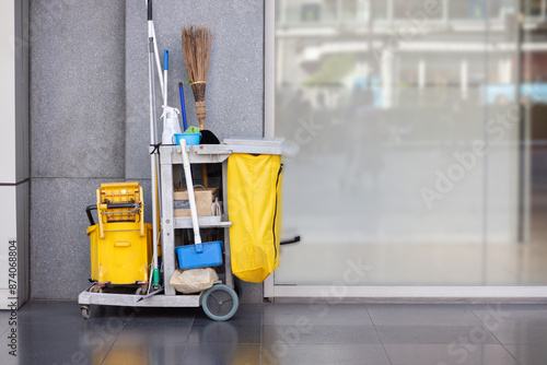Obraz na plátne A yellow cleaning cart with a yellow trash bag and a yellow bucket