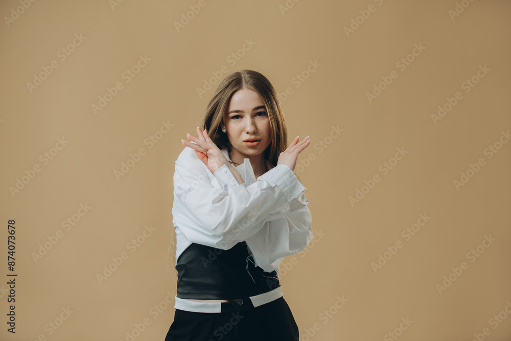 Young pretty blonde girl in a white shirt posing on a beige background. Young pretty blonde girl in a white shirt posing on a beige background.