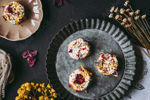 Obraz na płótnie Petits fromages de chèvre frais avec des graines et pétales fait-maison posés dans une assiette w salonie