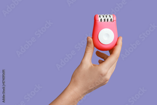 Wallpaper Mural Female hand with modern epilator on purple background Torontodigital.ca