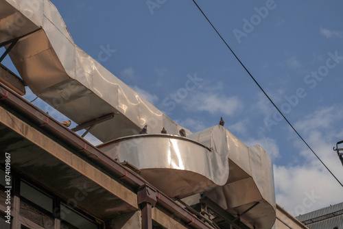 In the background, pigeons are sitting on a ventilation pipe. street birds. Pigeon feeder. High quality photo