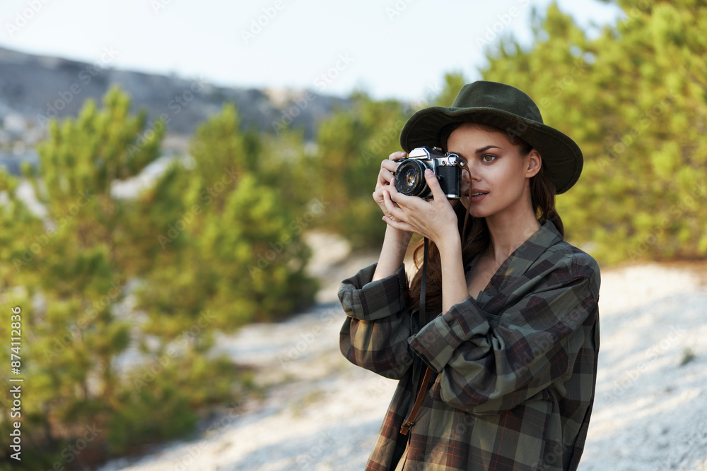 Stylish woman in plaid shirt and hat captures the moment with vintage camera in hand Stylish woman in plaid shirt and hat captures the moment with vintage camera in hand