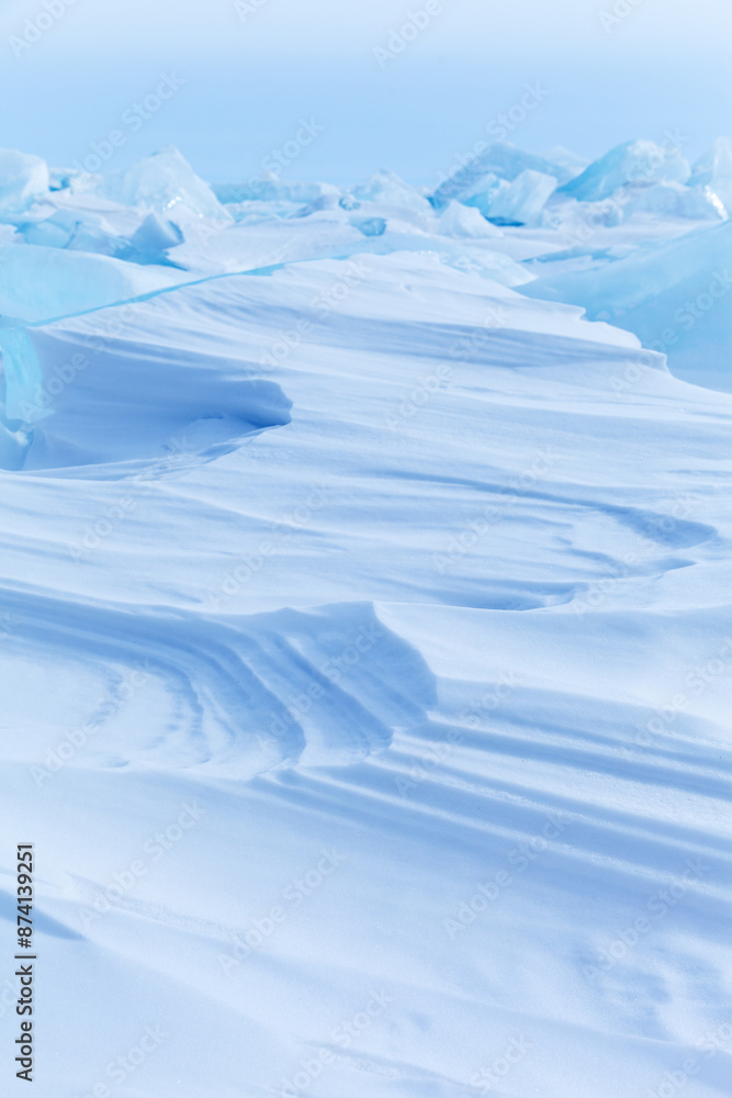 Blue and white abstract natural background of snowy ice surface of Baikal Lake on frosty winter day. View of layered snow texture of snow crust on ice field of frozen lake. Copy space, mock up, blank Blue and white abstract natural background of snowy ice surface of Baikal Lake on frosty winter day. View of layered snow texture of snow crust on ice field of frozen lake. Copy space, mock up, blank