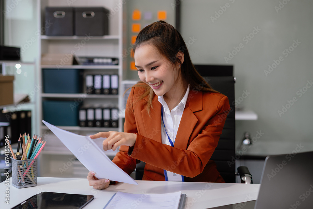 Business documents on the desk with a laptop and a Tablet with graphs, business diagrams and women working in the office. Business documents on the desk with a laptop and a Tablet with graphs, business diagrams and women working in the office.